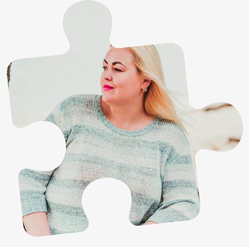 A woman sits on a tree branch looking out towards the horizon